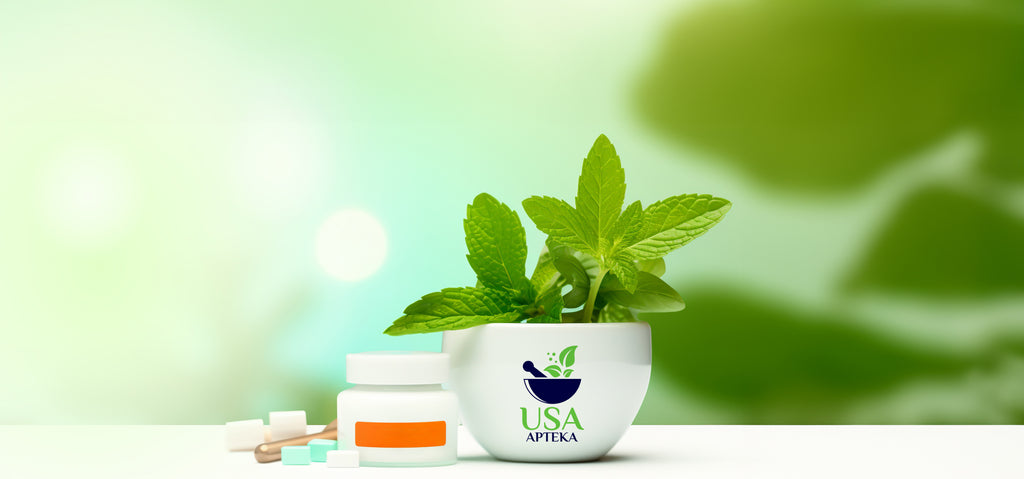 white bowl with mint and logo usa apteka standing on the table , tablets and plastic bottle with pills